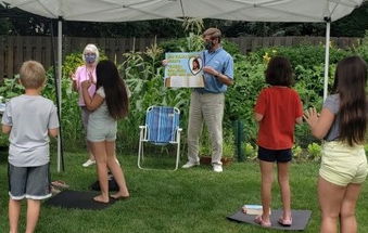 Teachers leading a song at a backyard 5-Day Club